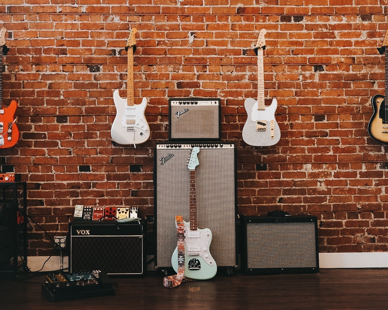 Lambertones guitar wall with amps and several electric guitars